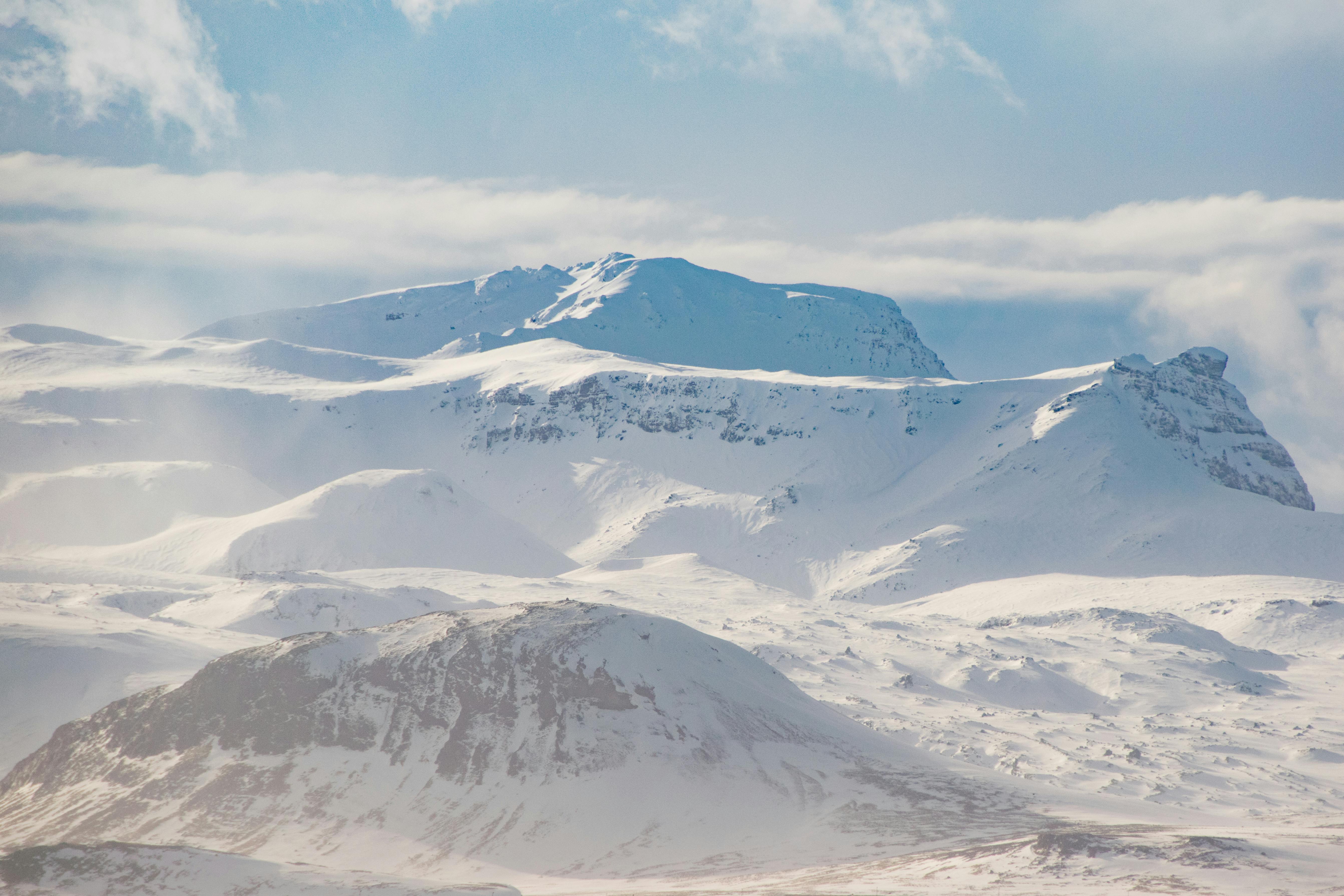 snow covered mountain ranges under the white skies