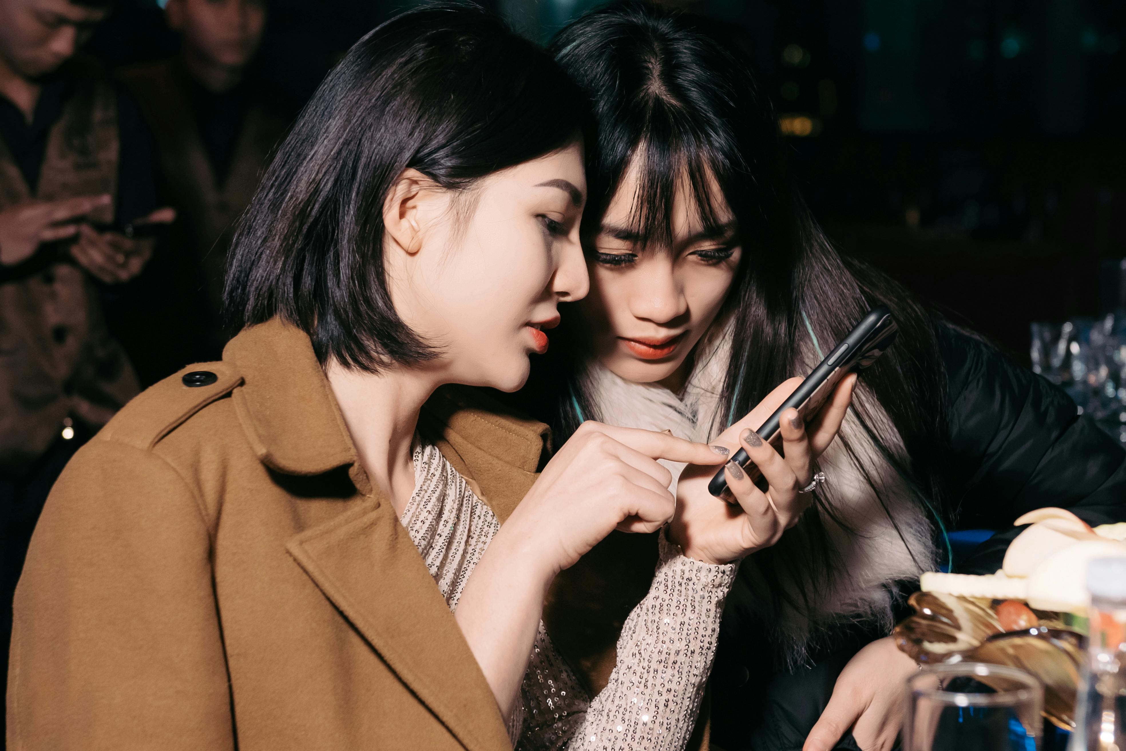 women looking at phone at party