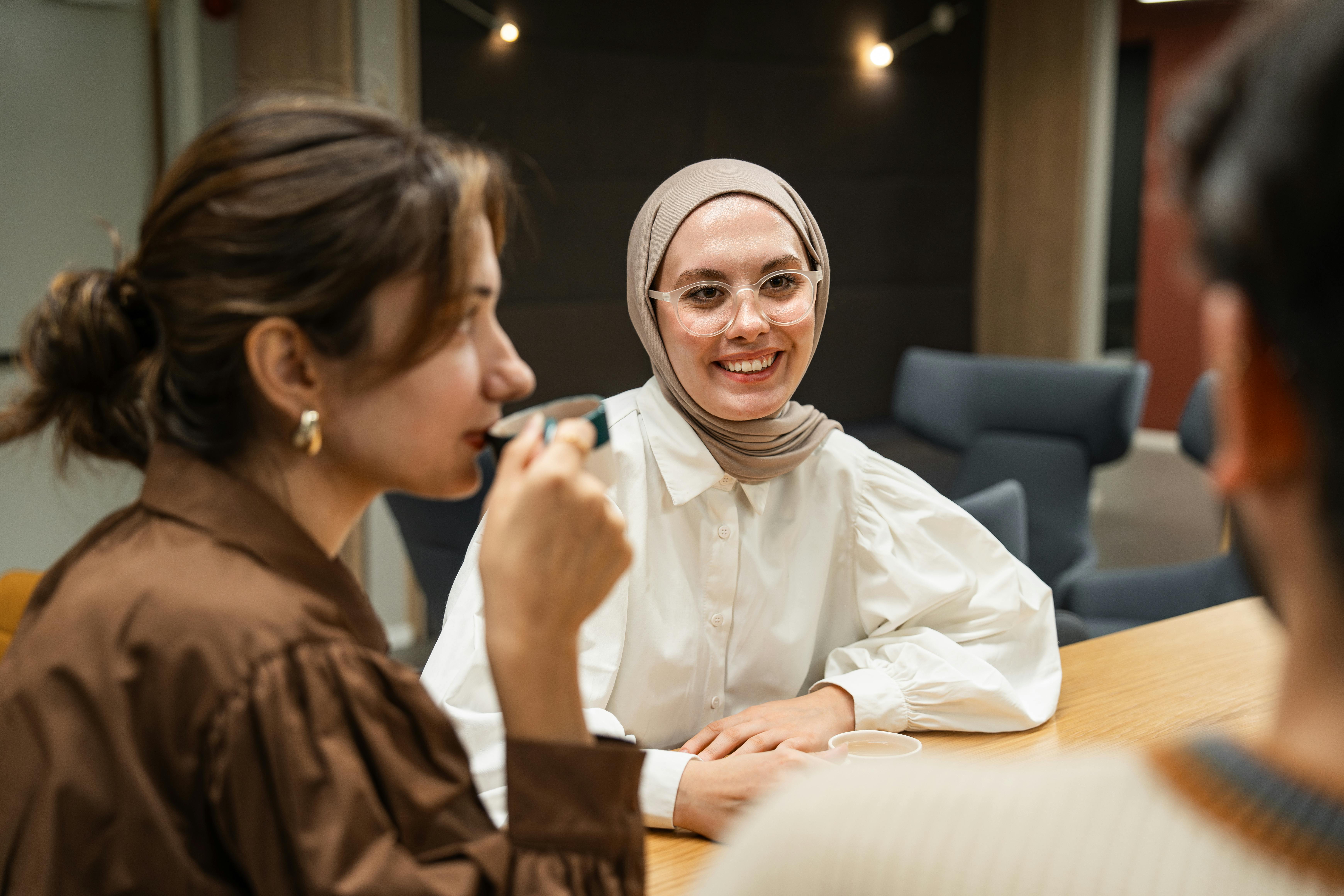 woman in hijab sitting with friends