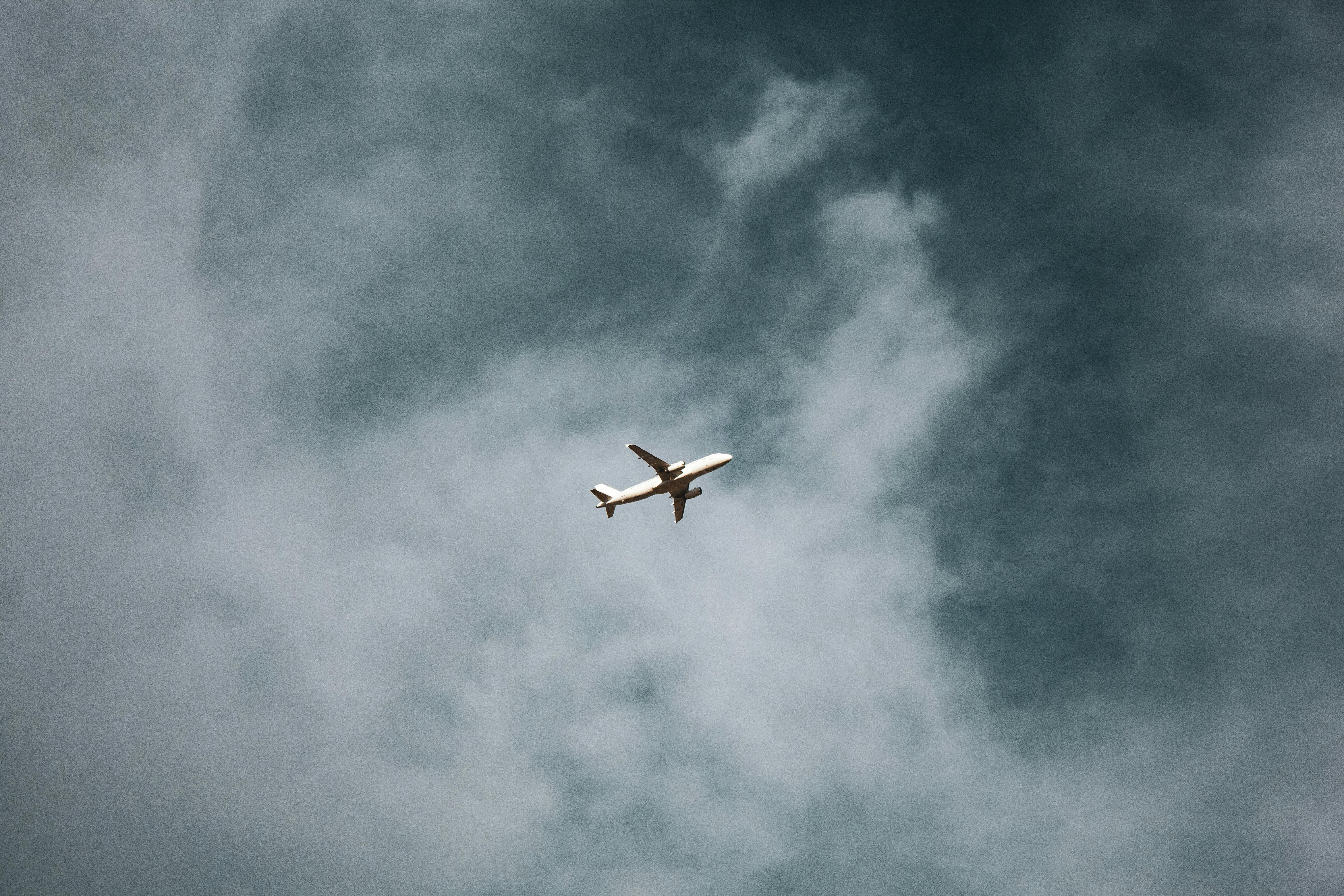 white plane on air under cloudy sky