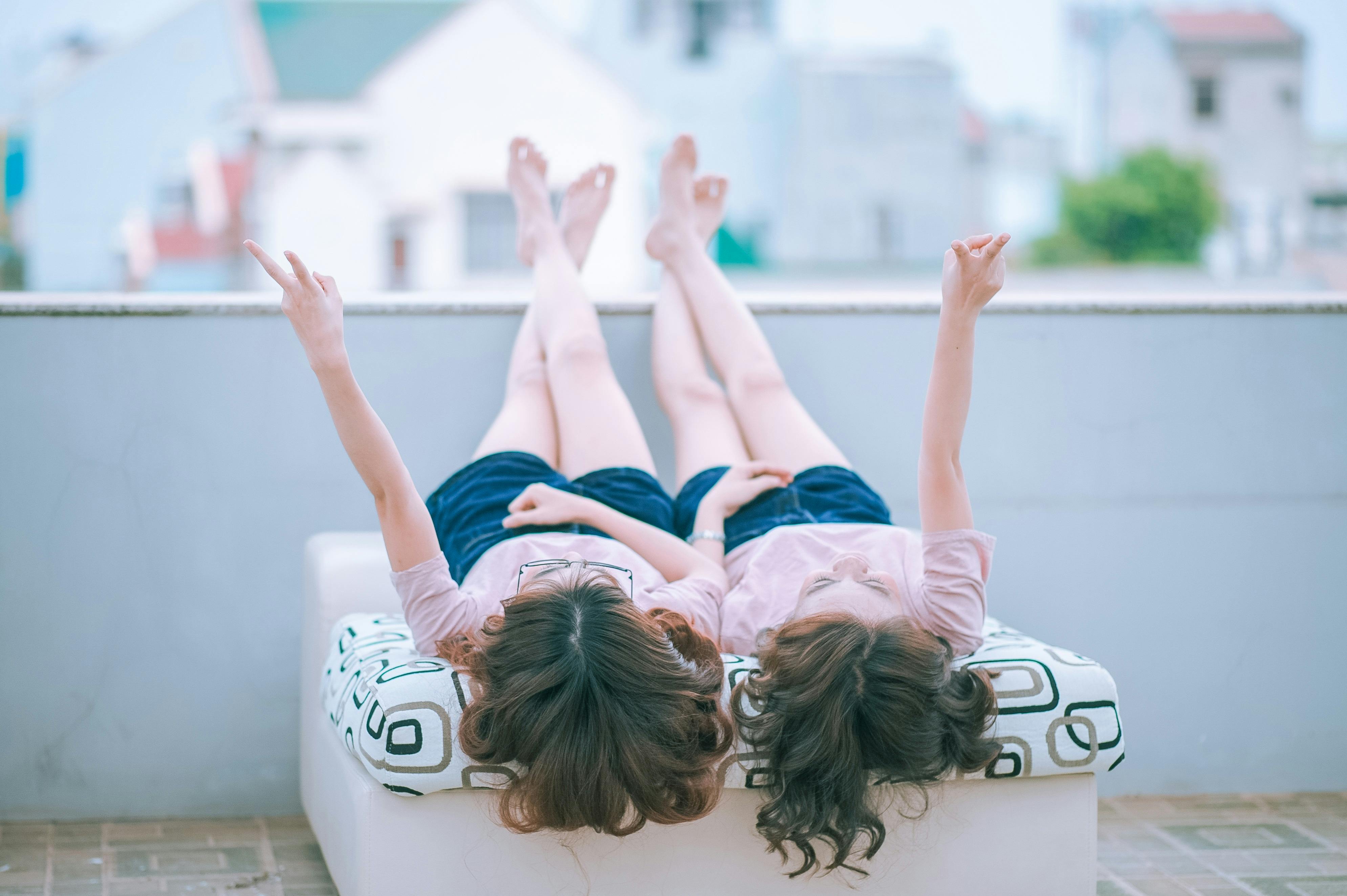 two person lying on white bed