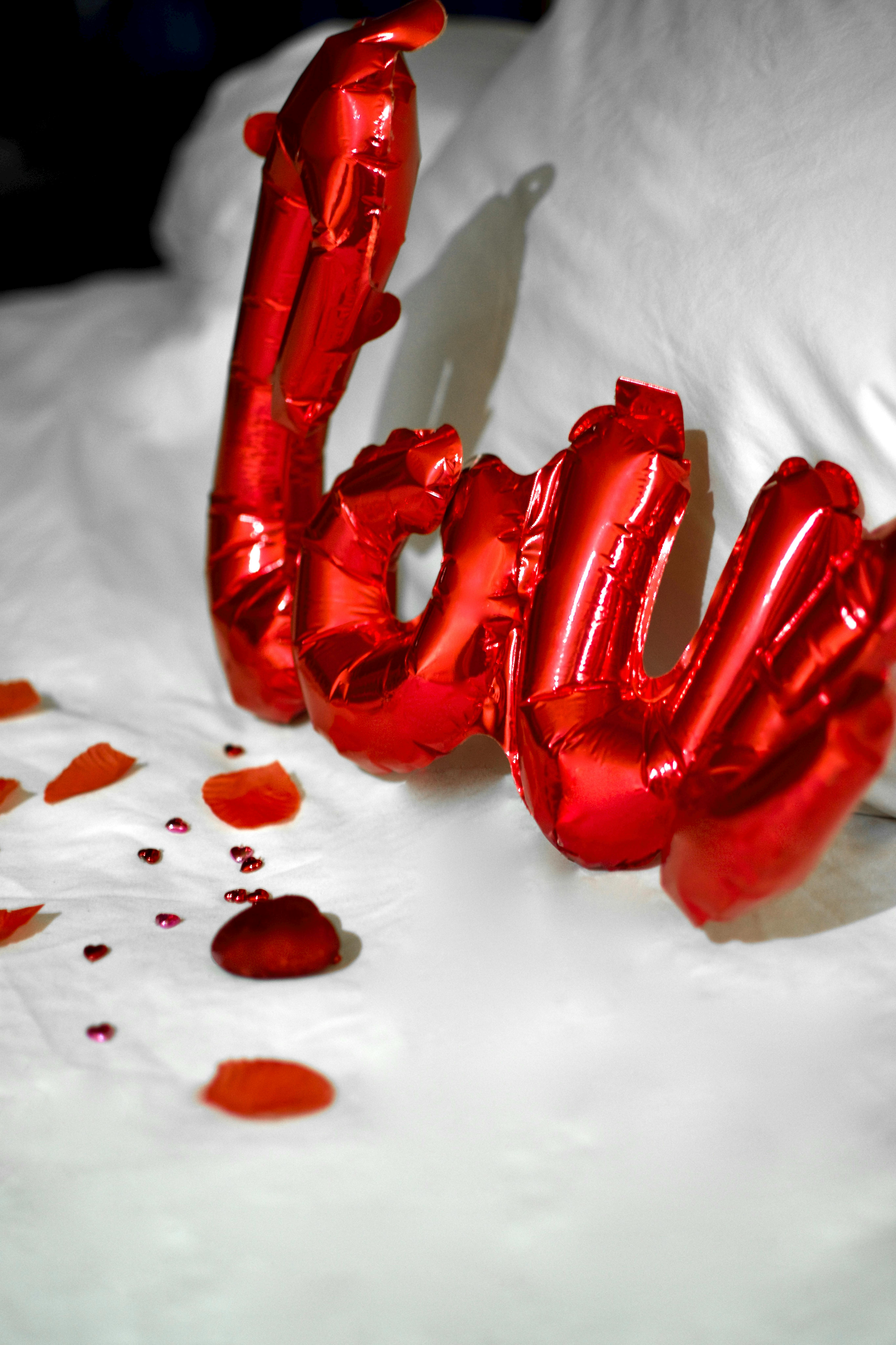 red plastic balloon on white textile