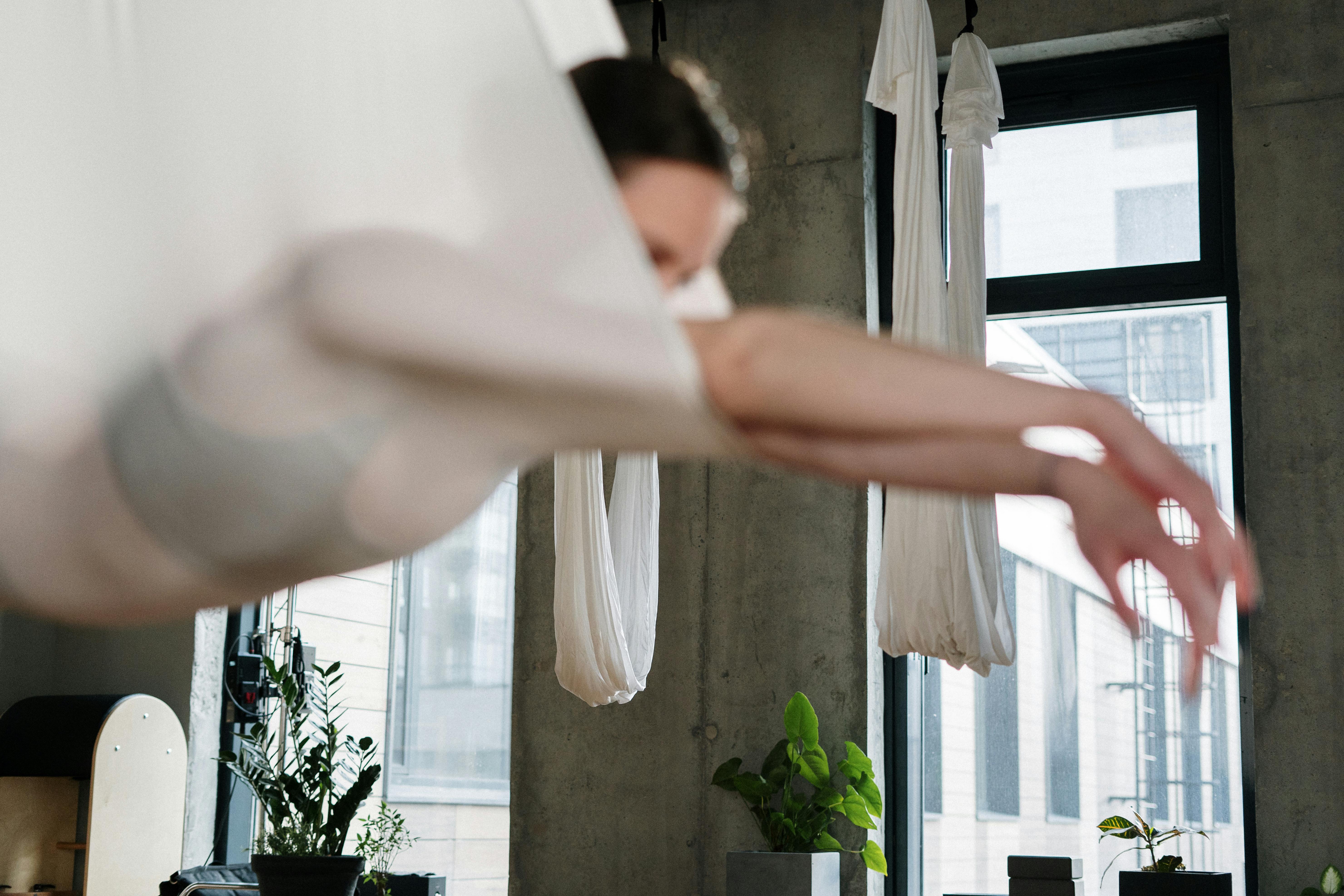 person holding white textile near green plant