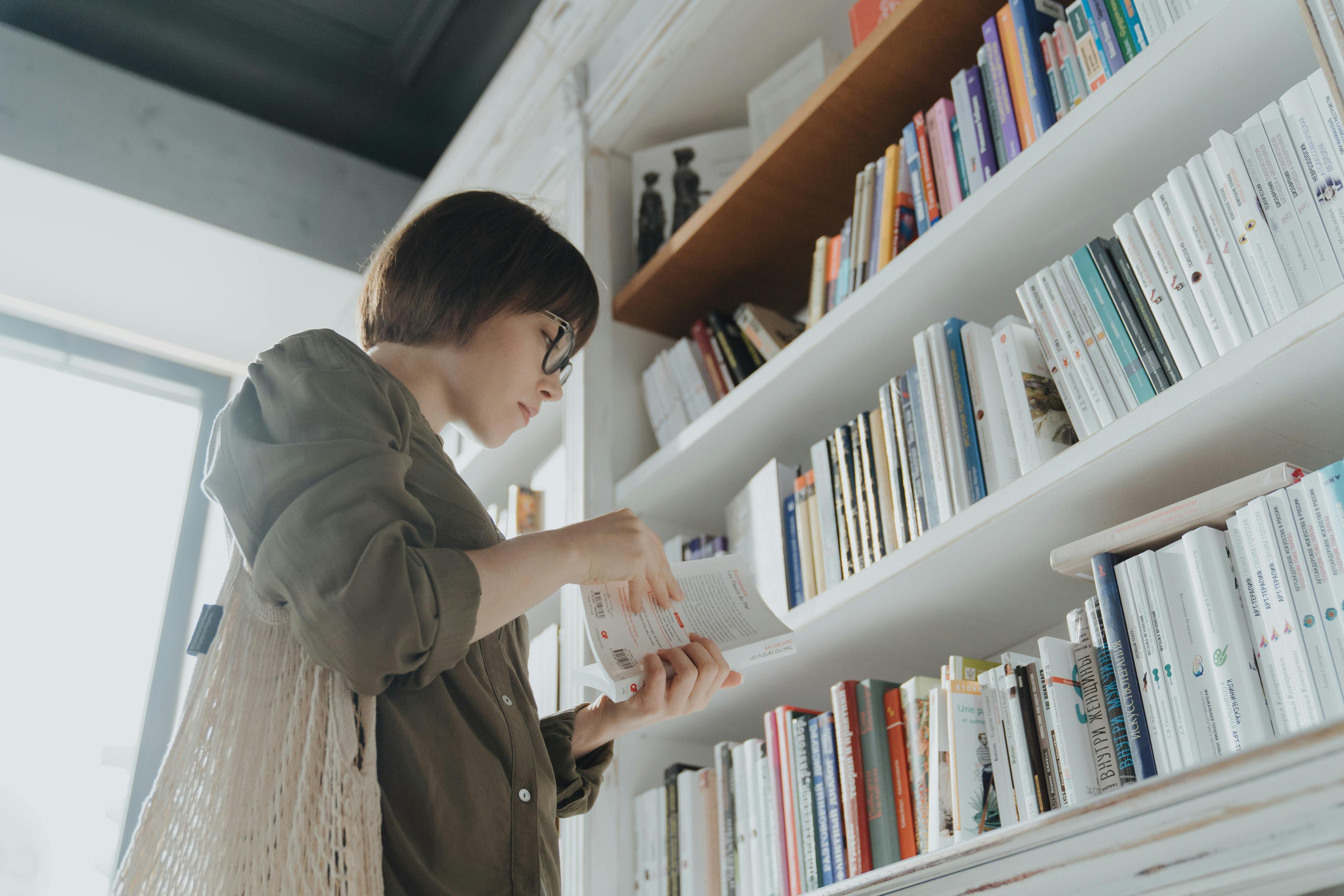 woman in gray coat reading books