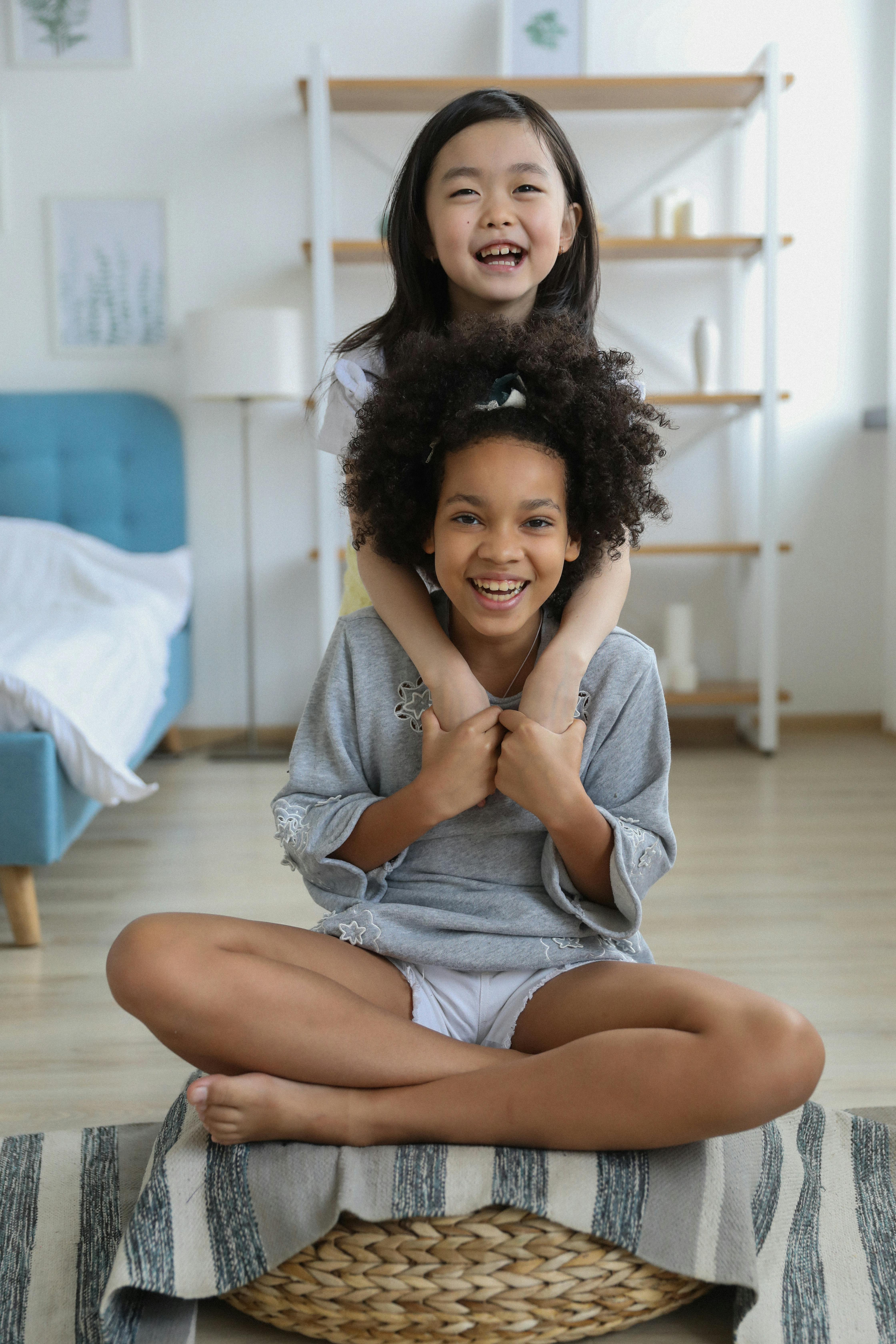 asian girl smiling and hugging friend in room