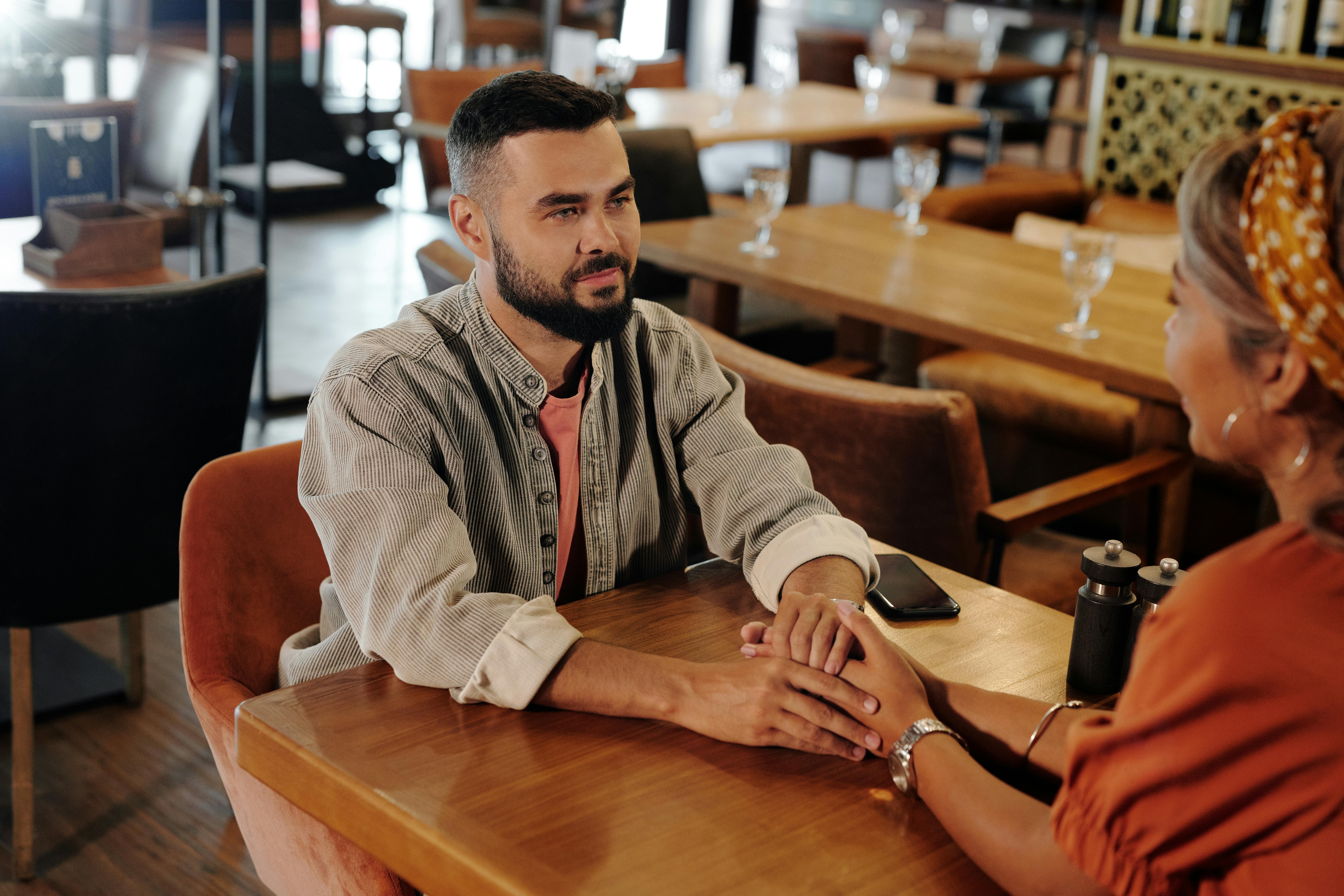 a couple inside a restaurant holding hands