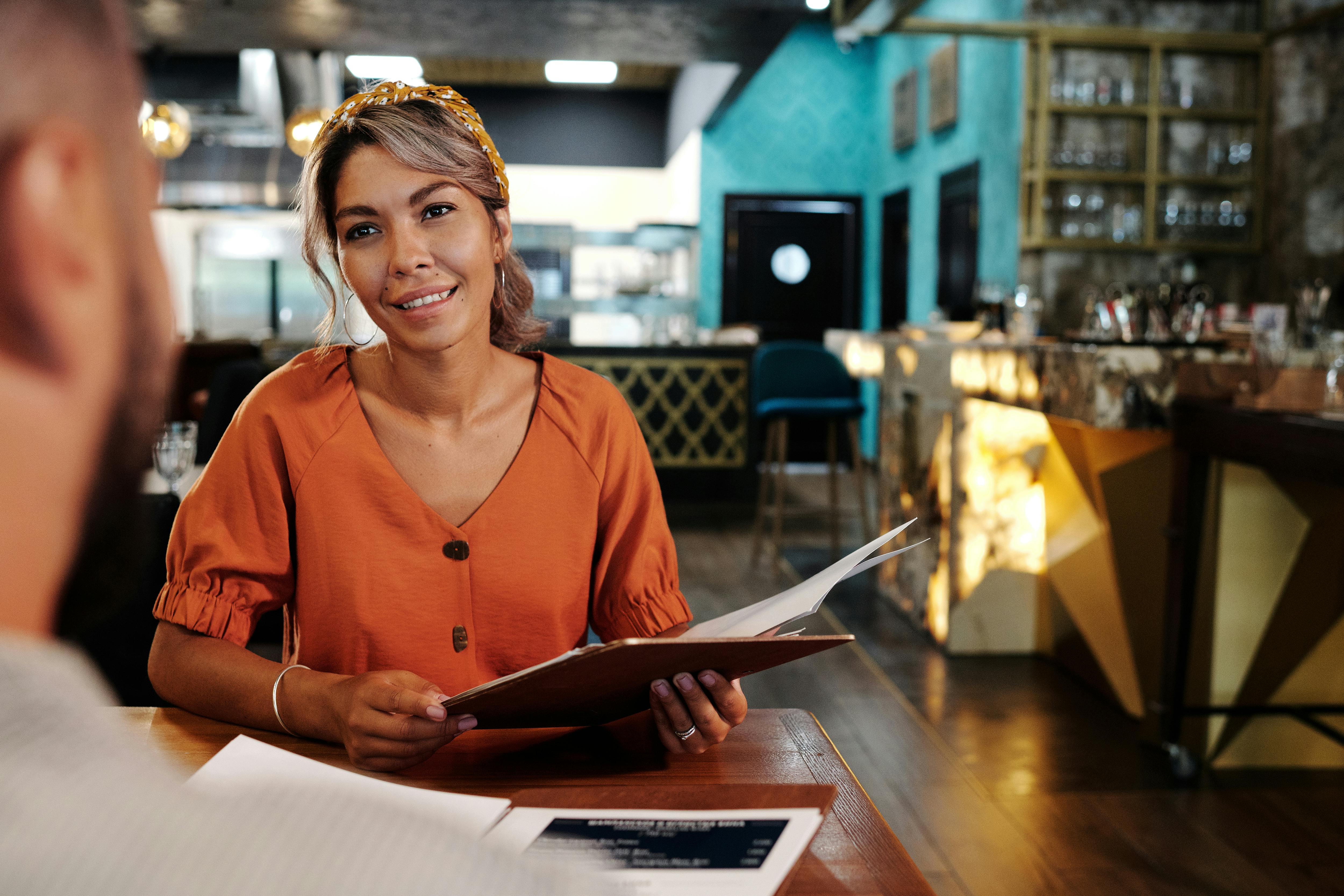a woman in orange blouse looking at her date