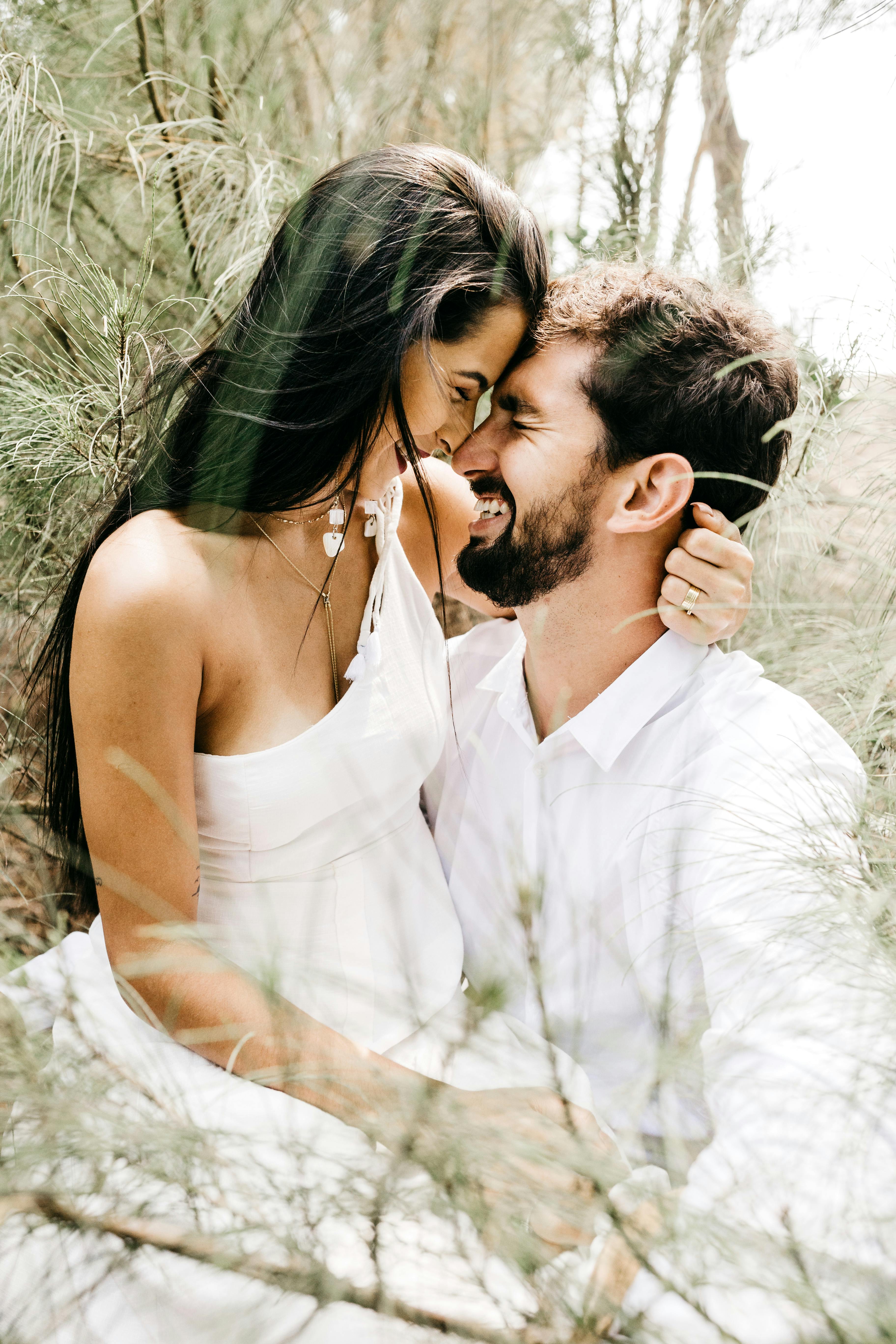 cheerful sweethearts hugging and laughing together