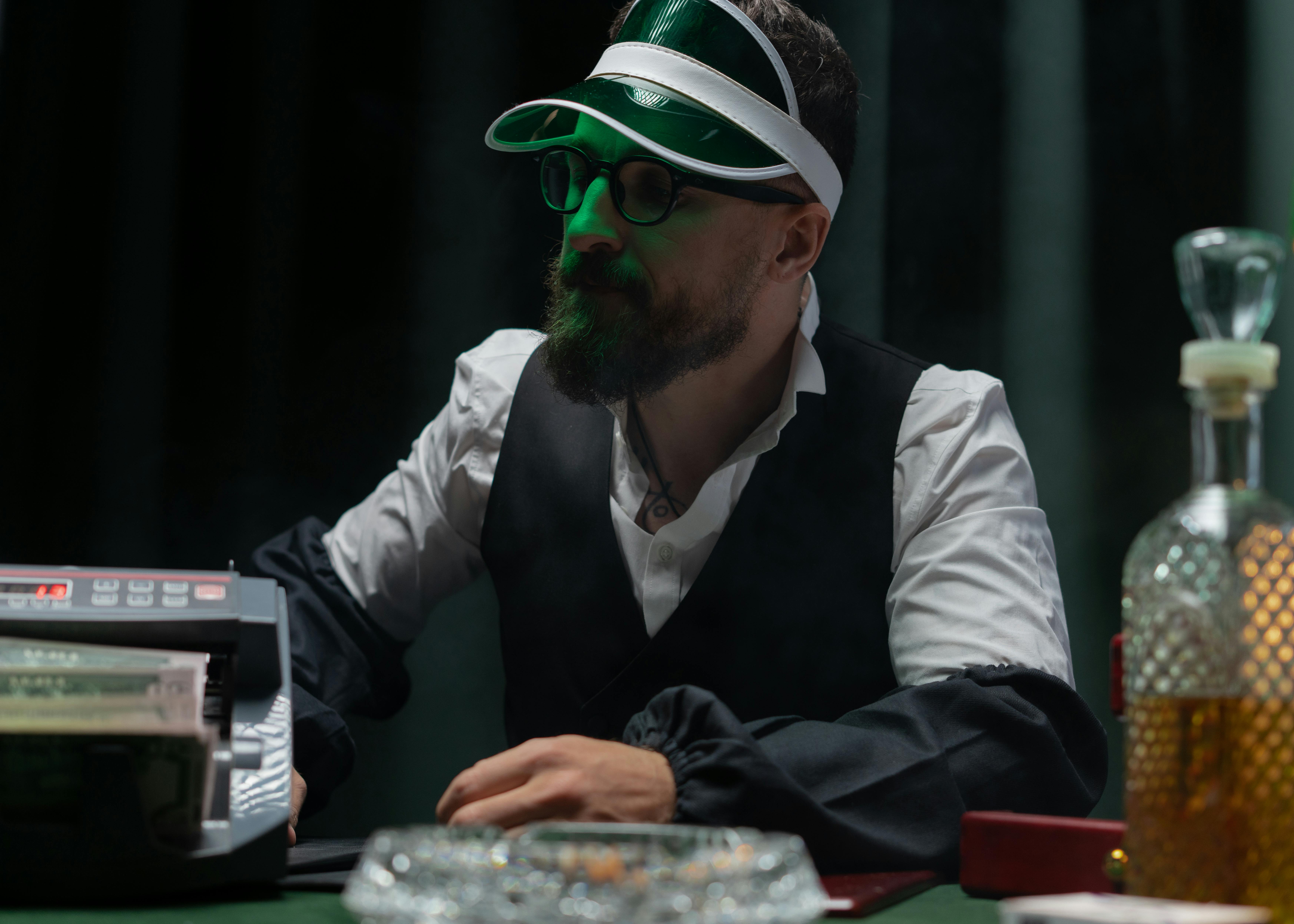 man in back vest wearing green cap