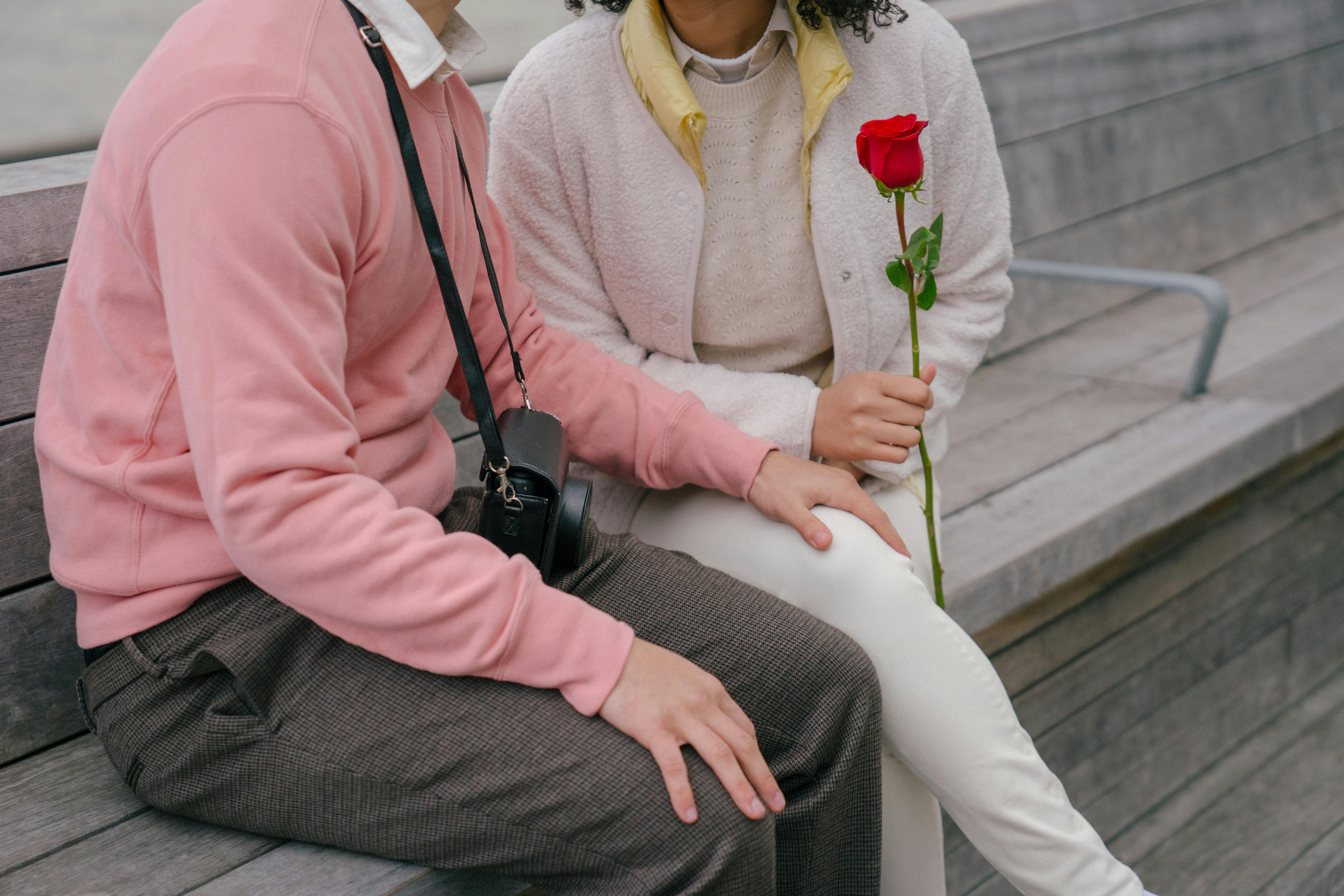 crop loving couple with flower on street