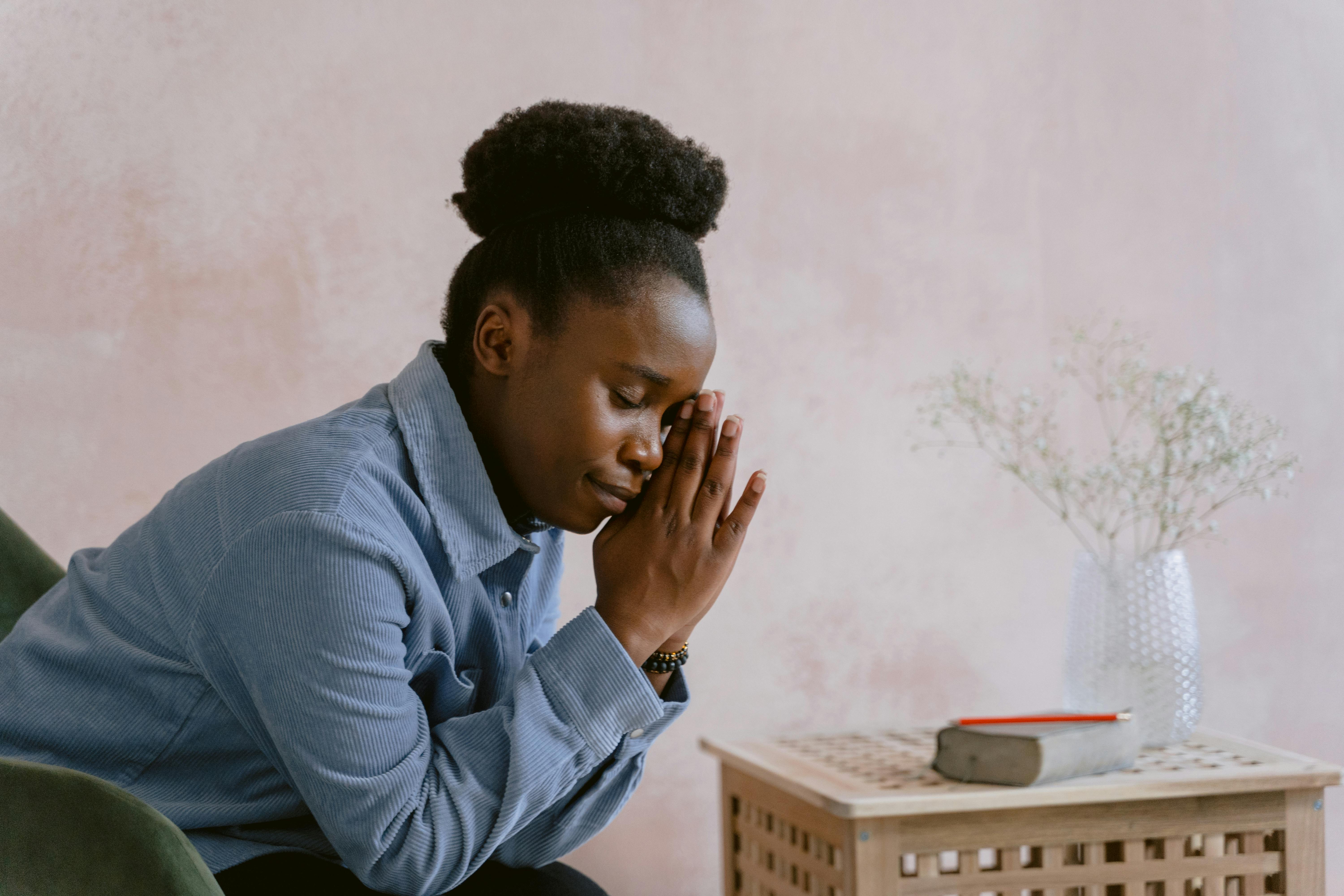 woman in blue dress shirt praying