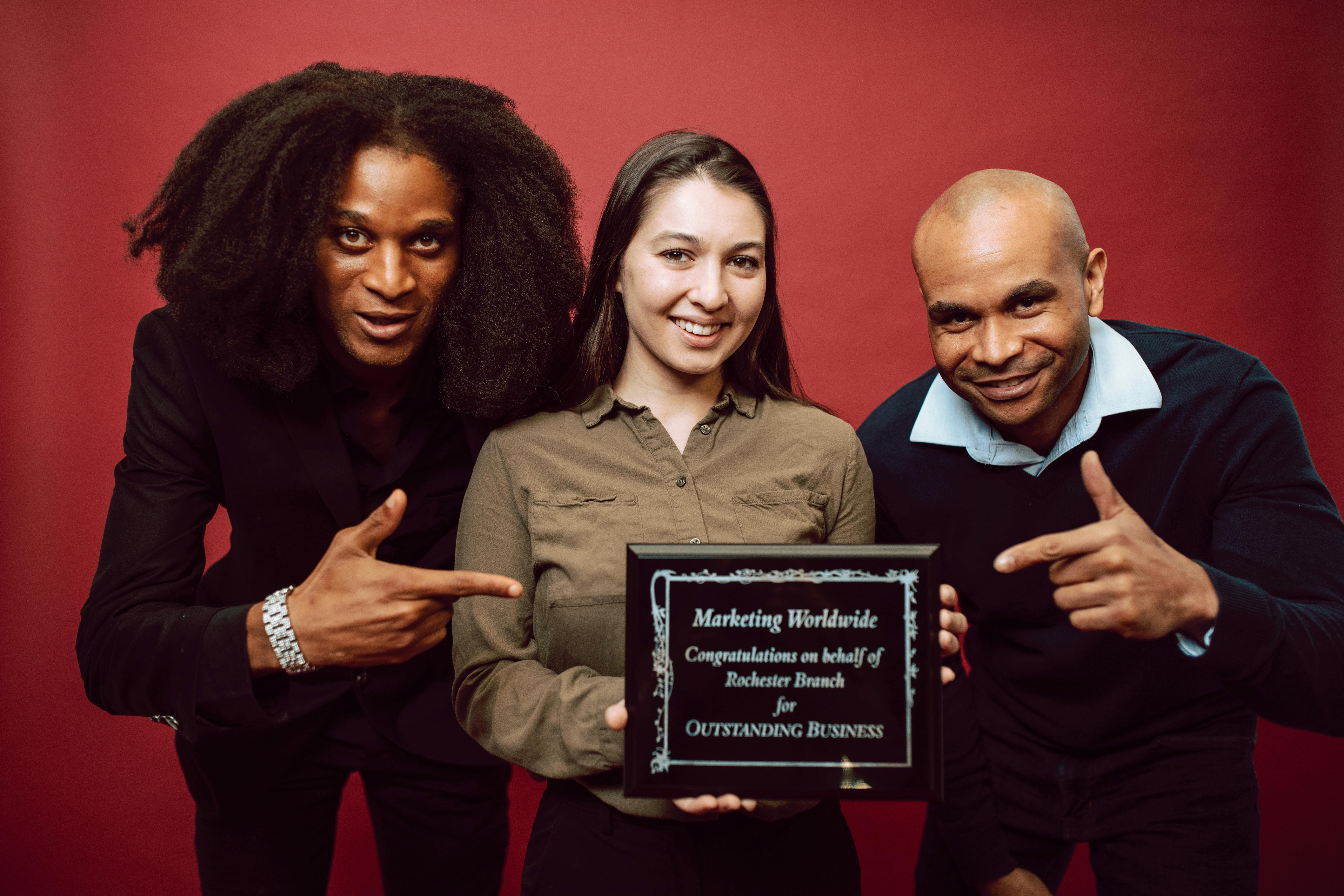 businesspeople posing with a recognition award