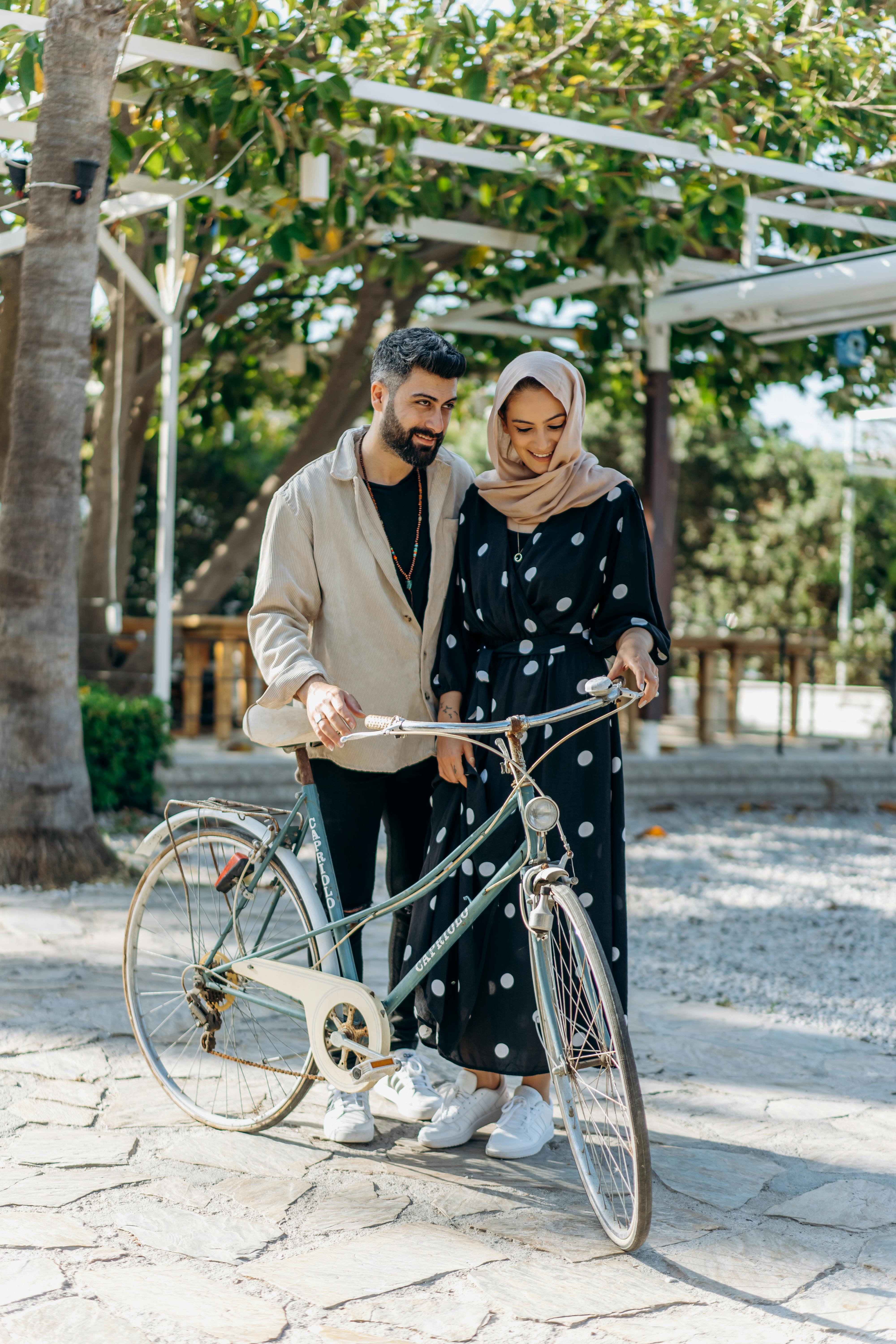 a couple standing beside a bicycle