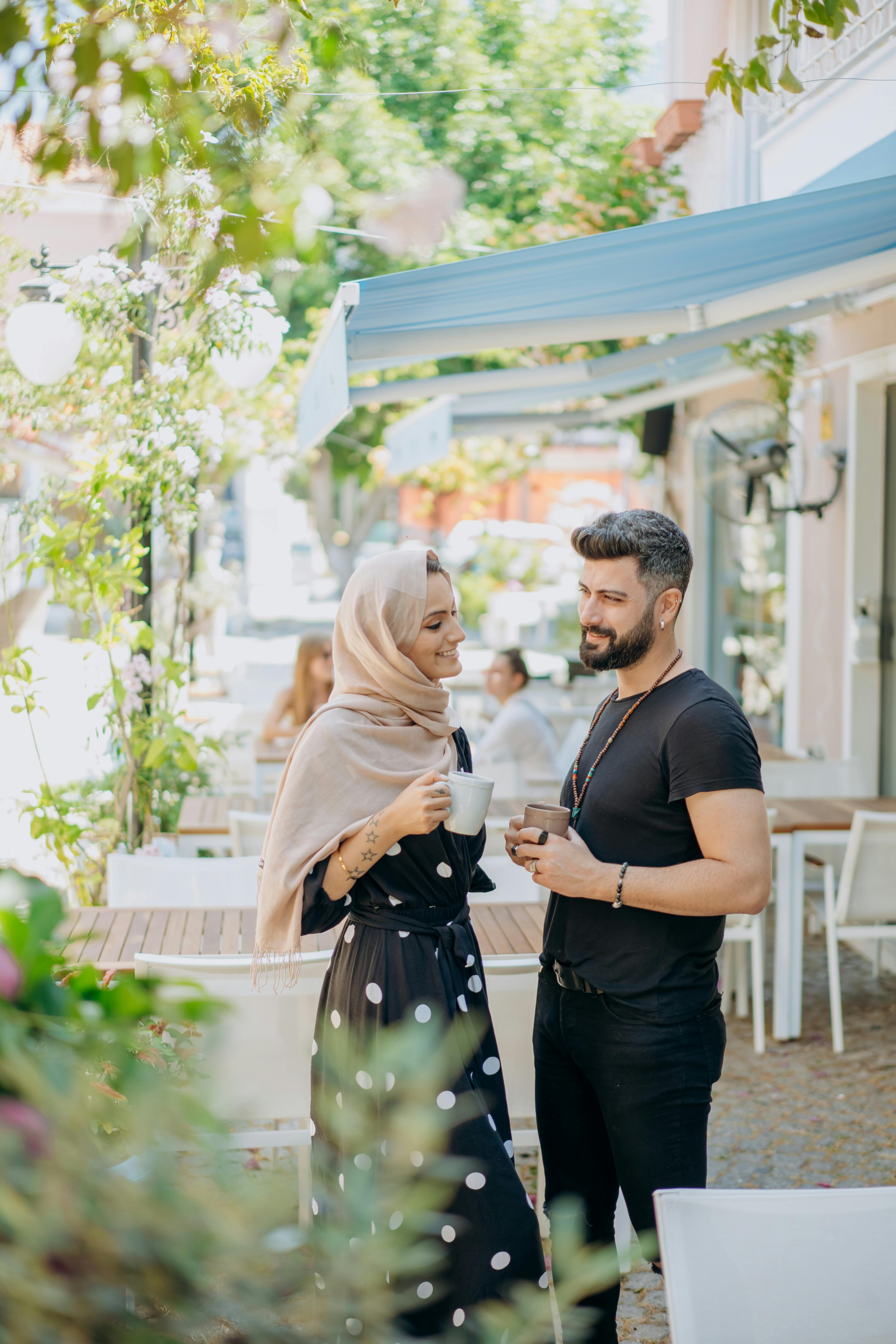 a couple standing while drinking coffee together