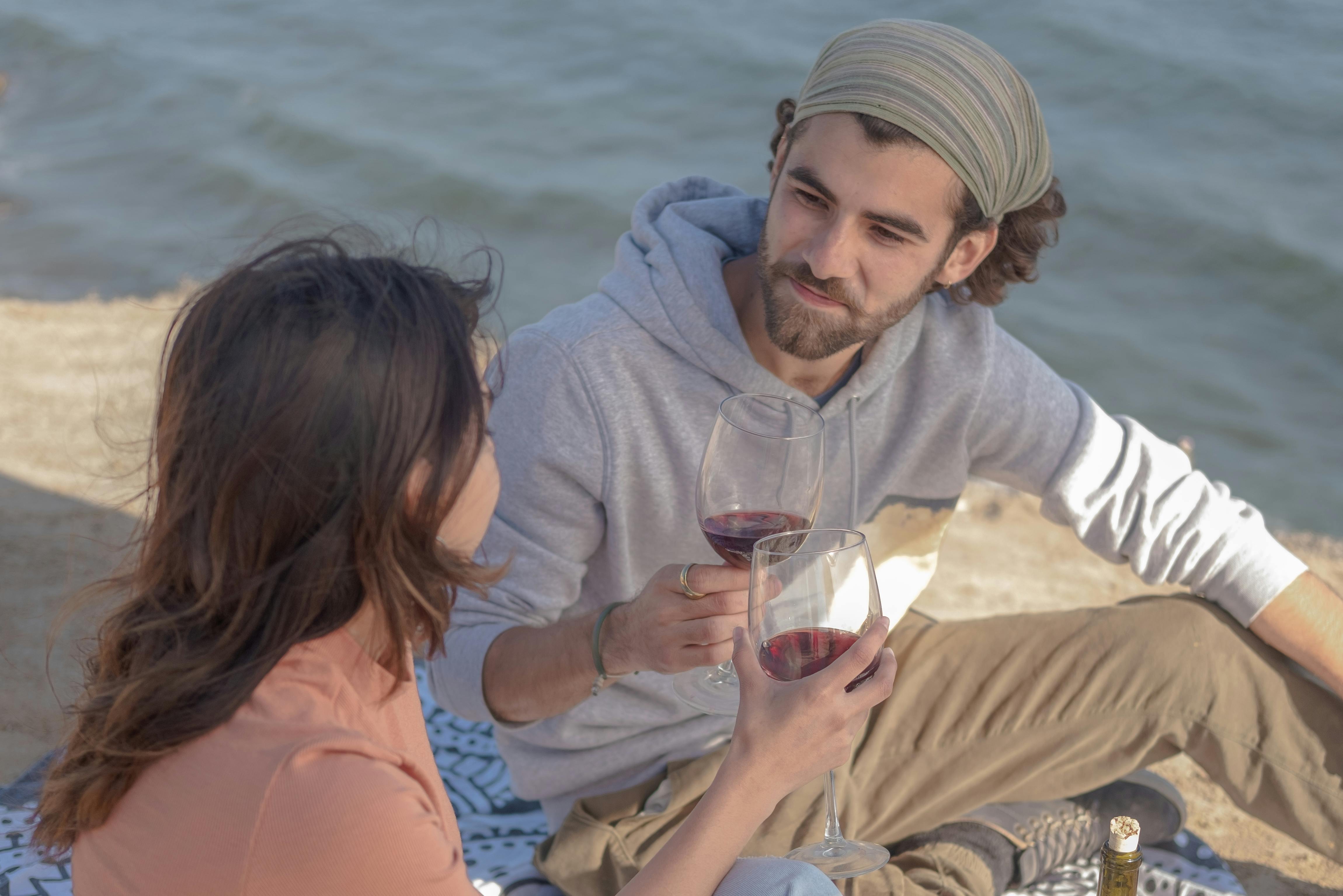 couple drinking red wine at the beach