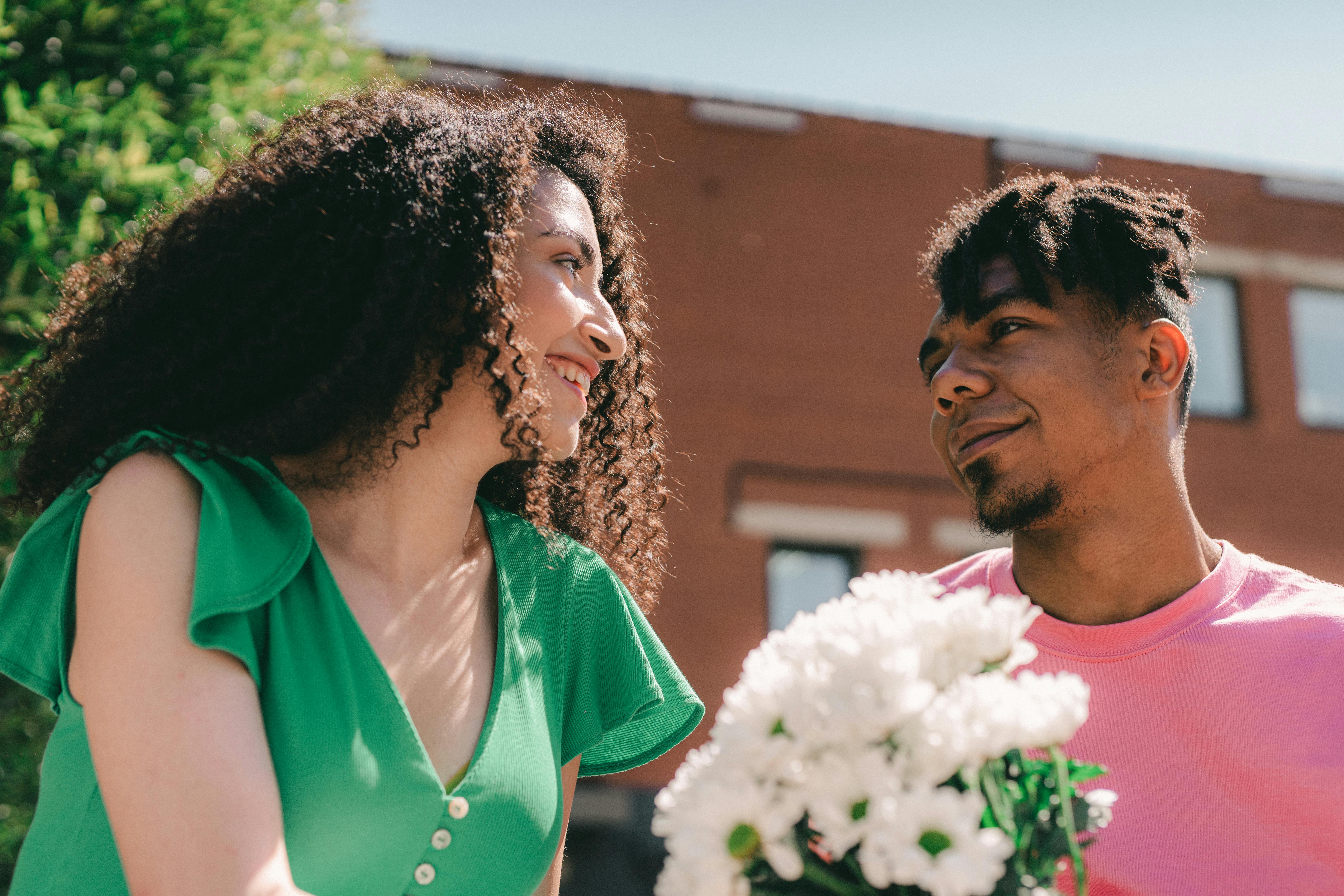 low angle shot of a man giving a woman a bouquet of flowers
