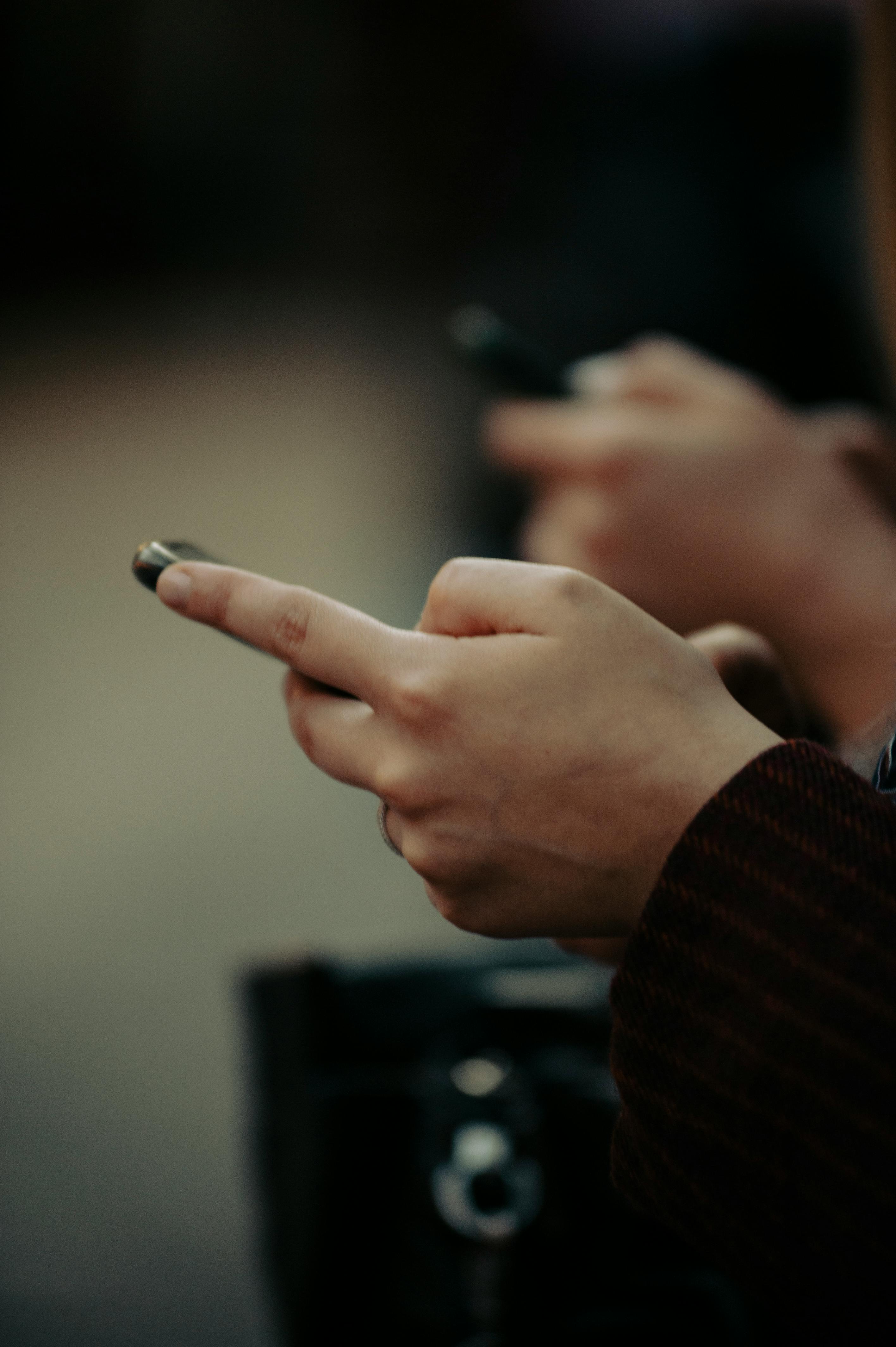 close up photo of person s hands holding smartphone