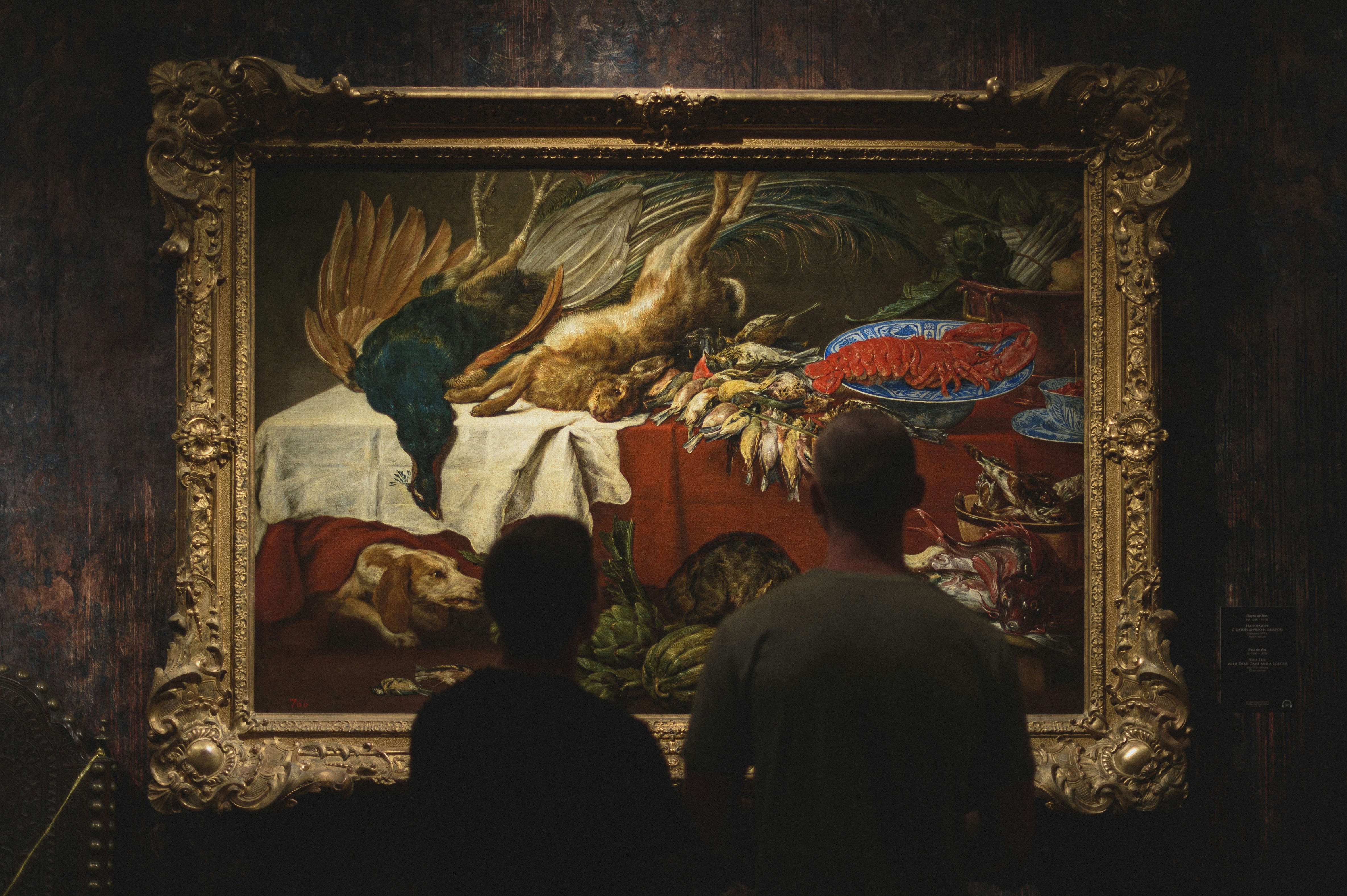 Visitors look at a Baroque still life.