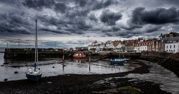 Pending Storm A dark storm approaches a port in Scotland just before sunset, a few small fishing boats await a rising tide in the port must be darrell stock pictures, royalty-free photos & images